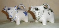Two Welsh cow creamers with pour holes on their foreheads