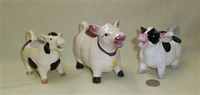 Three black and white cow creamers