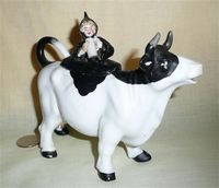 Lady with beer stein on lid of white cow creamer with black face and back