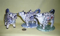 Three colorful small faience cow creamrs
