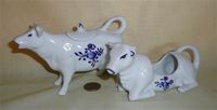 Two German white with blue cow creamers