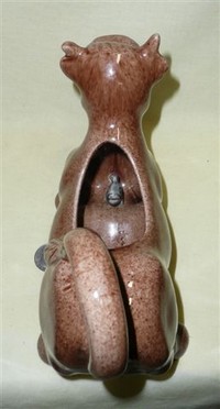 Brown cow creamer with large udder and green fish inside, top