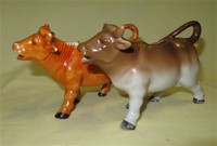 Orange and brown porcelain cow creamers