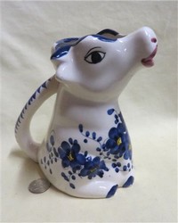 Sitting up flat headed cow creamer with blue flowers
