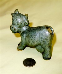 Small green cow with hole in butt