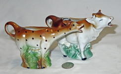 Two German brown and white cow creamers filled below and a companion Giraffe