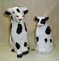 2 black & white cow pitchers