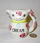 wjite cow pitcher with CREAM on chest