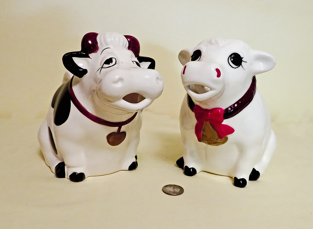 2 forlorn looking cow pitchers