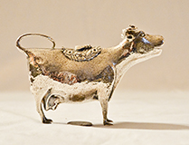 Chased silver cow creamers by John Schuppe