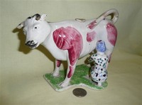 Red and white cow creamer with milkmaid in spotted dress