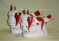 Two cow creamer spill vases with milkmaids at rear