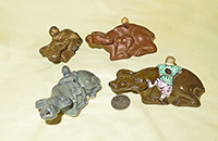 Four Chiinese water droppers of boy climing on water buffalo