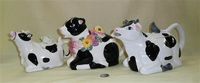 Three lying down cow teapots