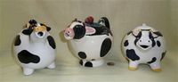 Three chubby cow teapots