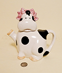 Sitting cow caricature teapot with hair bow