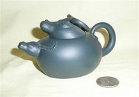 Small clay Chinese teapot with water buffalo heads for spout and lid