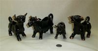 Four red clay Japanese black cow creamers with gold horns