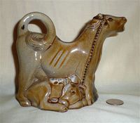 Guernsey Pottery brown cow creamer with kneeling milkmaid, right