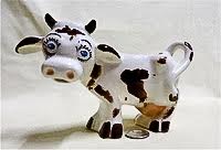 Forlorn black and white cow creamer with blue eyes