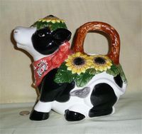 Sitting cow pitcher with daisys