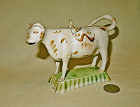 Small white cow creamer with brown marks