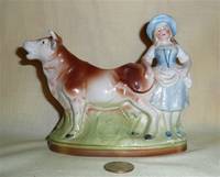 Porcelain cow creamer with fancy lady standing near tail