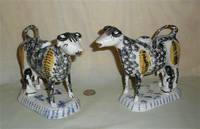 Matrched pair of black and yellow sponged Prattware cow creamers with armless milkmaids