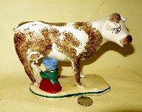 White and brown cow creamer with milkmaid