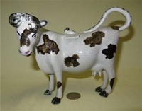 Grey cow creamer with black marks, crazing, and no base