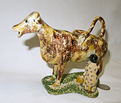 Brown and yellow early 1800s English cow creamer with milkmaid