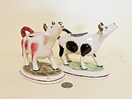 Pair of reproduction cow creamers with long nacks
					  and raised heads