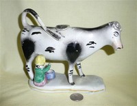 White & black cow creamer with milkmaid